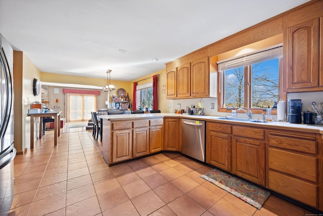 kitchen featuring kitchen peninsula, light tile patterned flooring, dishwasher, pendant lighting, and sink