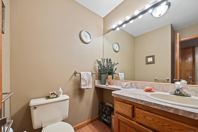 bathroom with toilet, vanity, and tile patterned flooring