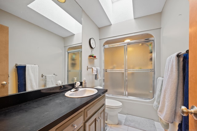 full bathroom with toilet, a skylight, enclosed tub / shower combo, tile patterned flooring, and vanity