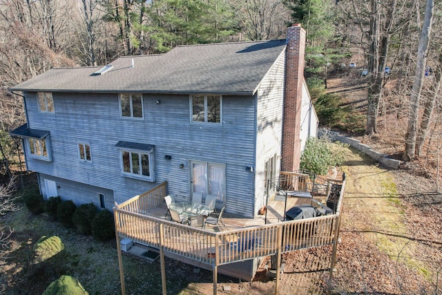 back of house with a deck and a garage