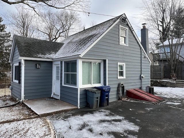 snow covered rear of property featuring a patio area