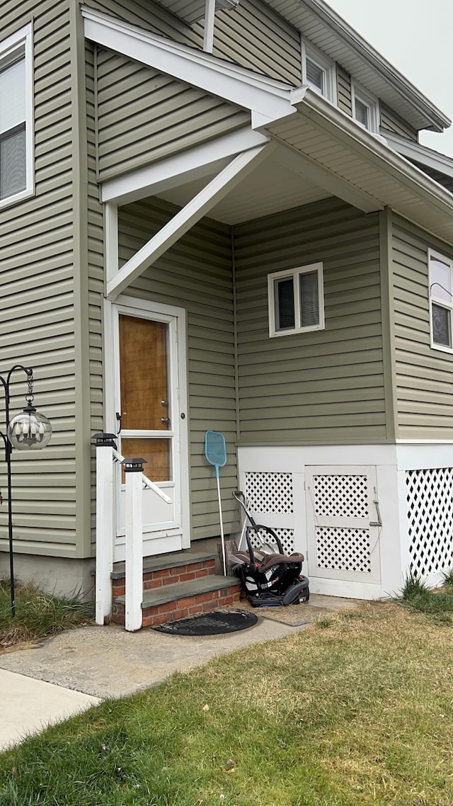 view of exterior entry with a lawn