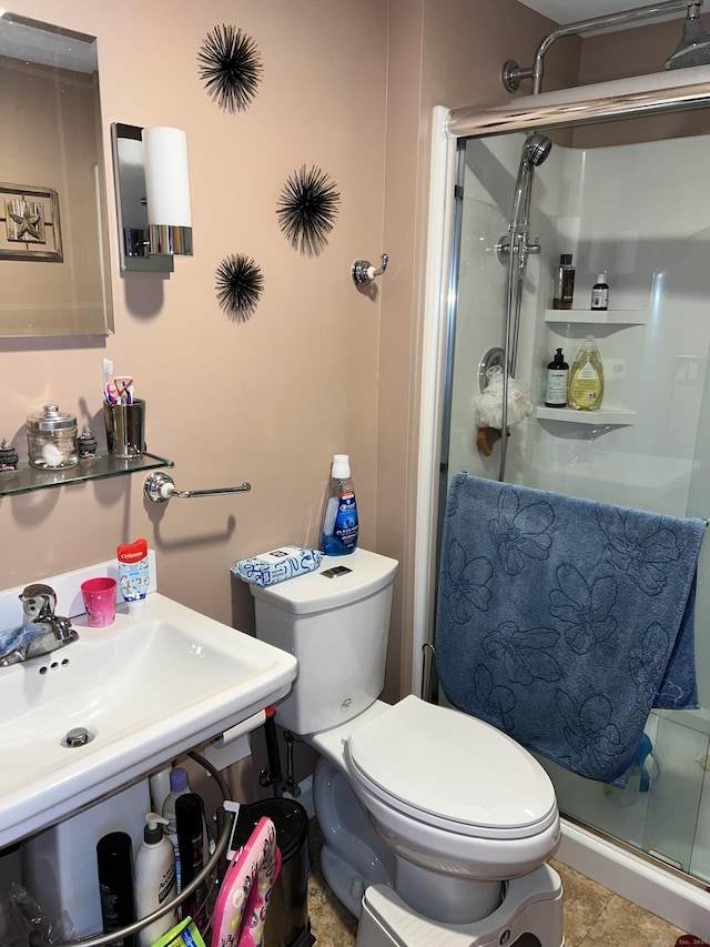 bathroom with toilet, sink, a shower with shower door, and tile patterned floors