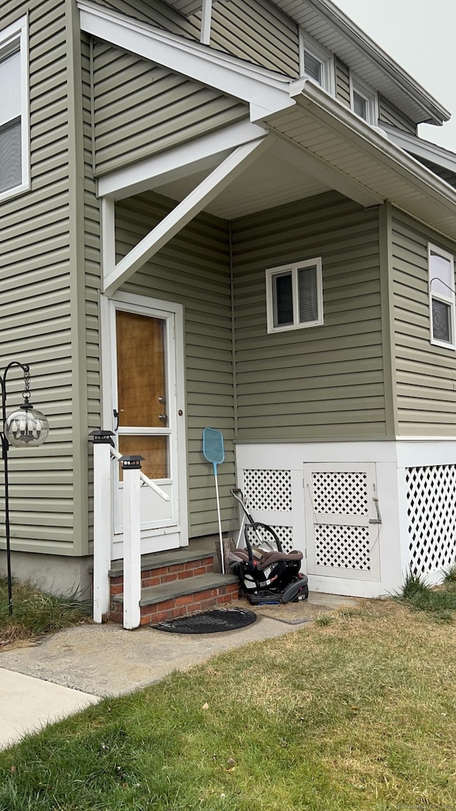 property entrance with a lawn