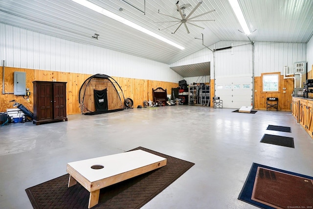 garage featuring electric panel, ceiling fan, and wooden walls