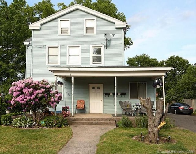 view of front of house featuring covered porch and a front lawn