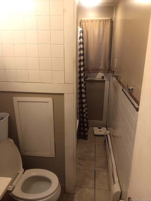 bathroom featuring a baseboard radiator, shower / bath combo, tile patterned flooring, toilet, and tile walls