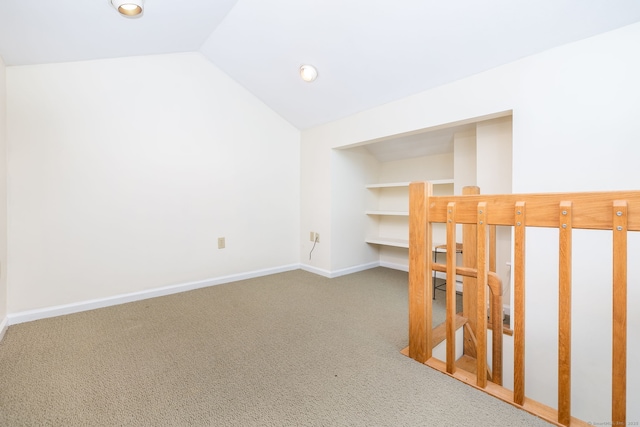 interior space with carpet flooring, built in features, and vaulted ceiling