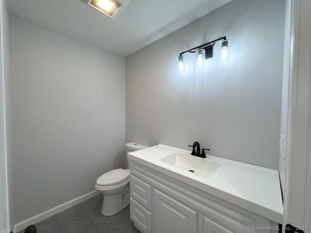 bathroom with toilet, vanity, baseboards, visible vents, and tile patterned floors