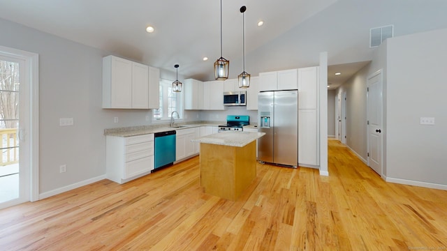 kitchen with visible vents, a kitchen island, hanging light fixtures, stainless steel appliances, and white cabinetry