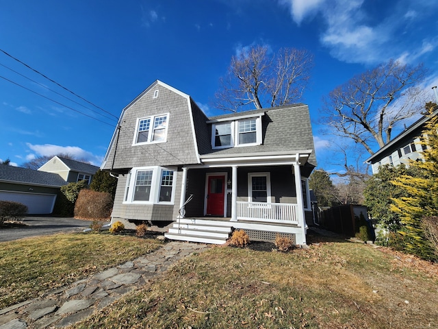 new england style home with a front lawn and covered porch