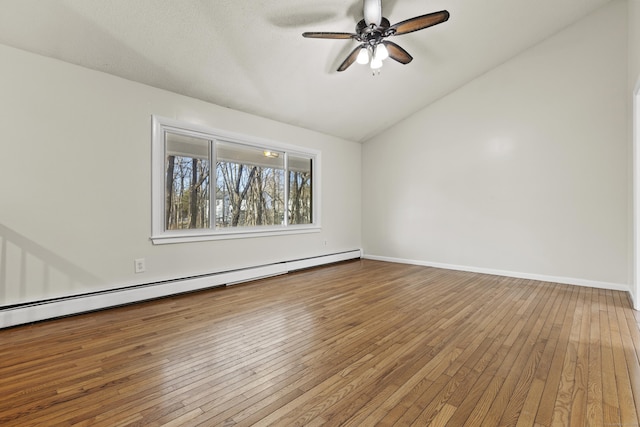 empty room featuring ceiling fan, baseboard heating, wood-type flooring, and lofted ceiling