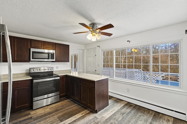 kitchen featuring a baseboard heating unit, appliances with stainless steel finishes, a healthy amount of sunlight, and kitchen peninsula