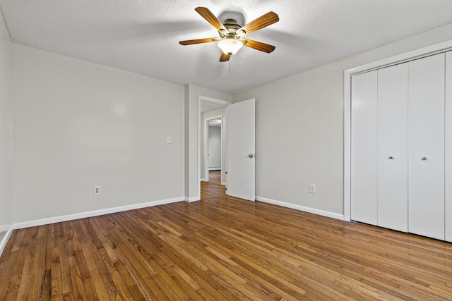 unfurnished bedroom featuring ceiling fan, a closet, a textured ceiling, and light hardwood / wood-style flooring