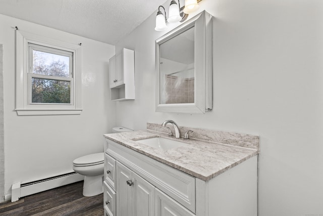 bathroom with toilet, vanity, hardwood / wood-style flooring, a textured ceiling, and a baseboard radiator