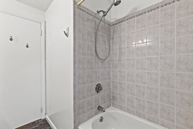 bathroom featuring tiled shower / bath combo and hardwood / wood-style flooring