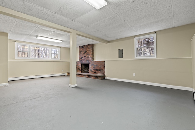 basement featuring a paneled ceiling, a baseboard heating unit, a brick fireplace, and electric panel