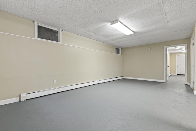 basement with baseboard heating and a drop ceiling