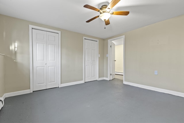 unfurnished bedroom with ceiling fan, two closets, and a baseboard heating unit