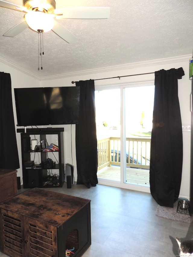 living room featuring a textured ceiling, ceiling fan, and ornamental molding