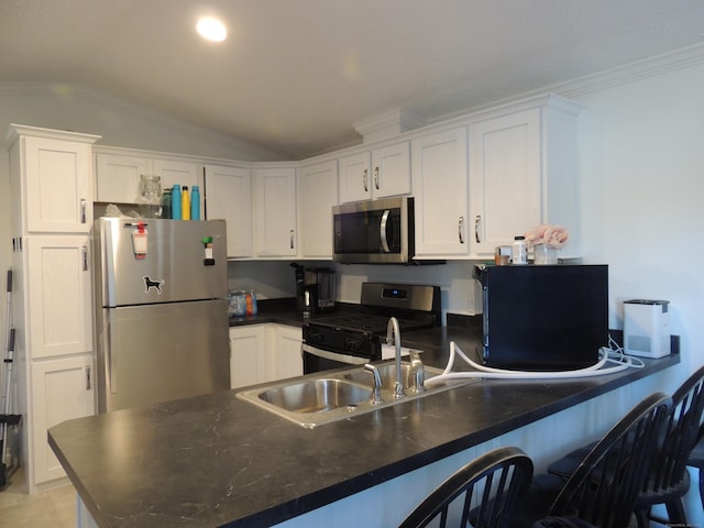 kitchen featuring white cabinets, stainless steel appliances, lofted ceiling, and sink