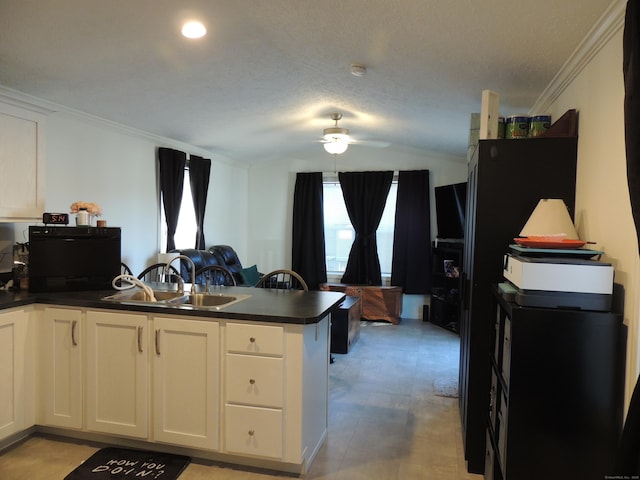 kitchen featuring white cabinetry, sink, ceiling fan, kitchen peninsula, and crown molding