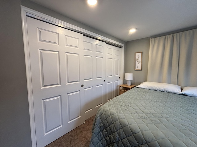 bedroom featuring a closet and dark colored carpet