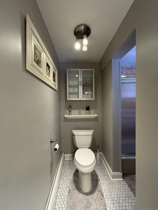 bathroom featuring a baseboard radiator, tile patterned floors, and toilet