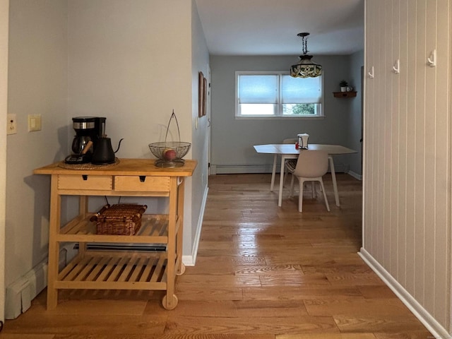 dining area with hardwood / wood-style floors and a baseboard heating unit