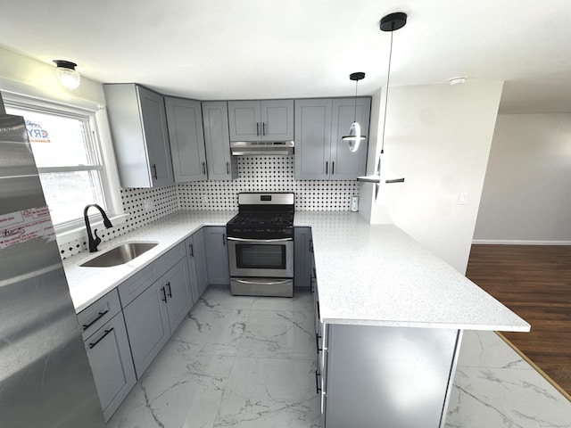 kitchen with gas range, kitchen peninsula, pendant lighting, gray cabinets, and sink