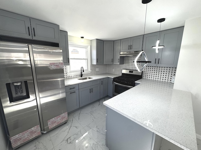 kitchen featuring appliances with stainless steel finishes, gray cabinetry, kitchen peninsula, sink, and decorative light fixtures