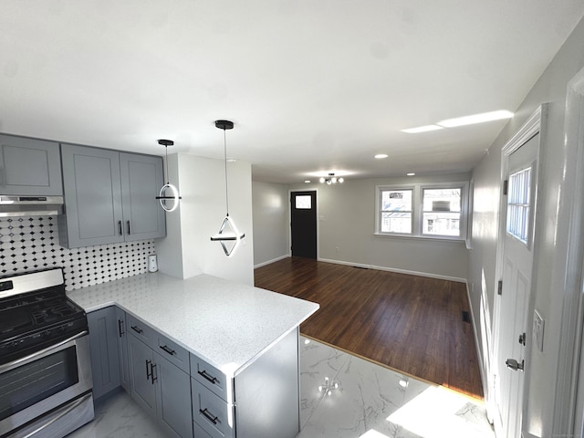 kitchen featuring kitchen peninsula, stainless steel gas range oven, gray cabinetry, and tasteful backsplash