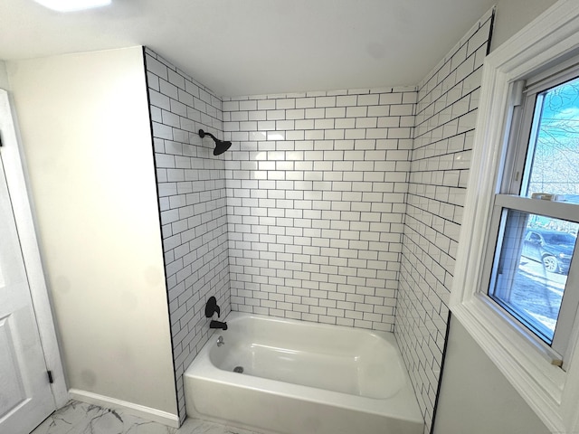 bathroom featuring plenty of natural light and tiled shower / bath