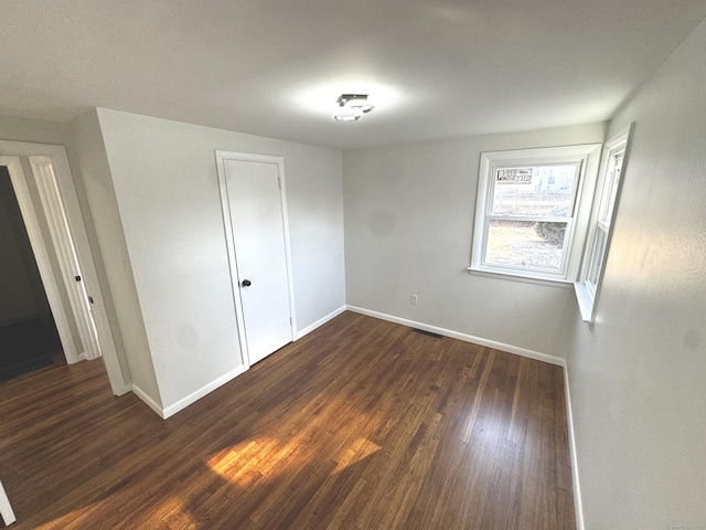 unfurnished bedroom featuring a closet and dark hardwood / wood-style floors