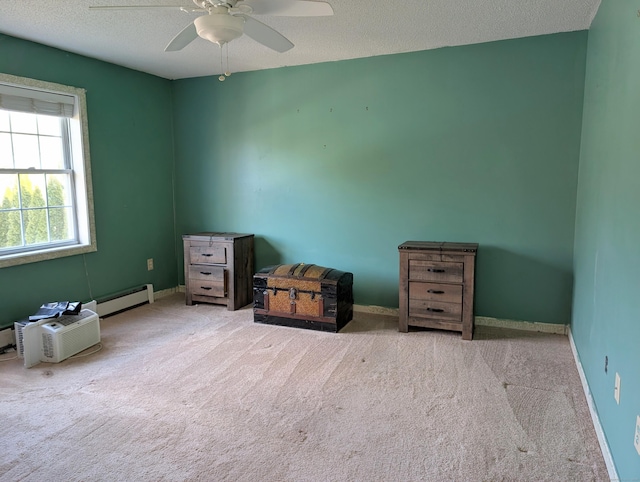 spare room with a textured ceiling, ceiling fan, baseboard heating, and light carpet