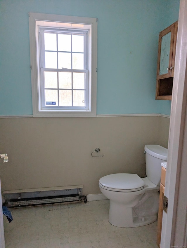 bathroom with vanity, toilet, and a baseboard heating unit