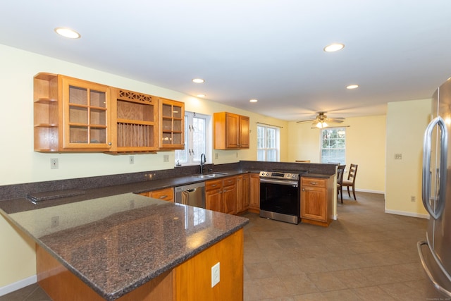 kitchen with ceiling fan, sink, appliances with stainless steel finishes, and kitchen peninsula