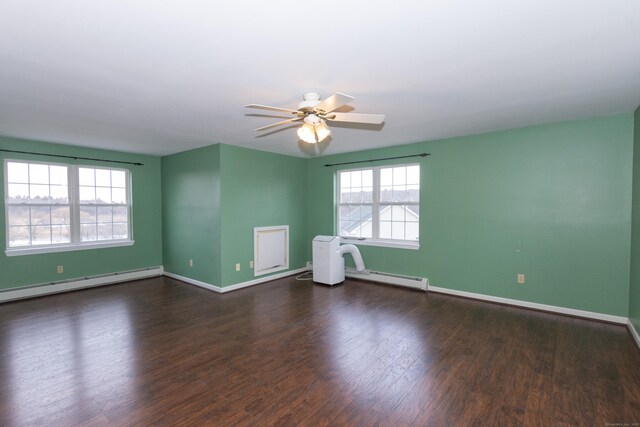 spare room featuring dark wood-type flooring, ceiling fan, and a baseboard radiator