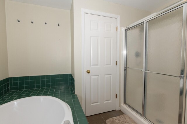 bathroom featuring shower with separate bathtub and tile patterned flooring