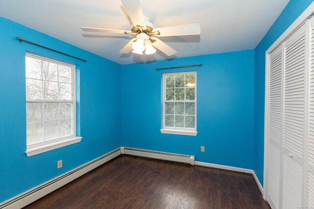 unfurnished bedroom with ceiling fan, a baseboard radiator, a closet, and dark hardwood / wood-style flooring