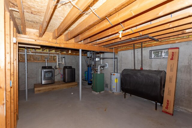 basement with water heater, a wood stove, and washer / clothes dryer