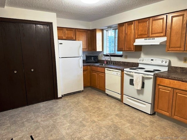 kitchen with white appliances, a textured ceiling, and sink