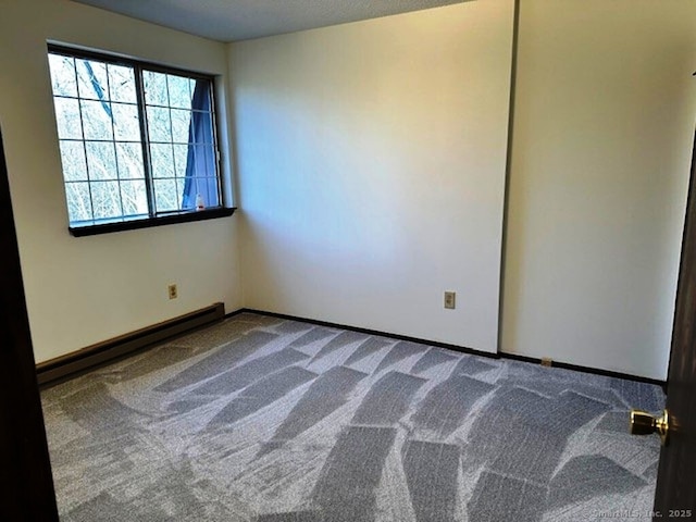 empty room featuring a baseboard radiator and carpet