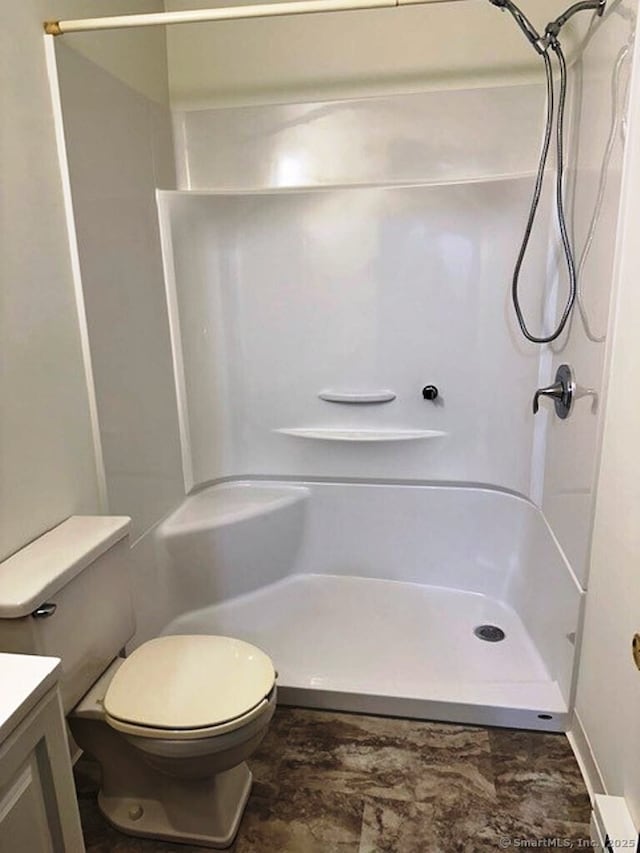 bathroom with toilet, vanity, and walk in shower