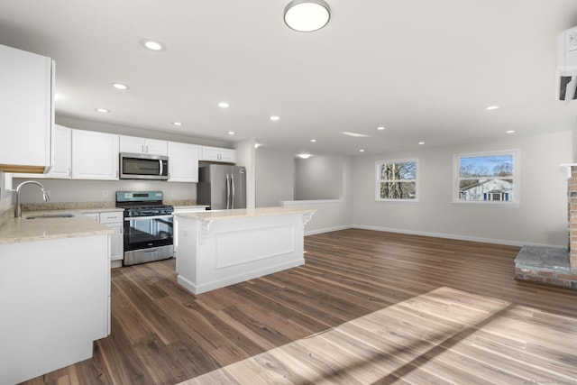 kitchen with stainless steel appliances, a kitchen island, dark hardwood / wood-style flooring, white cabinetry, and sink