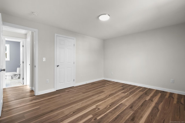 empty room with dark hardwood / wood-style flooring