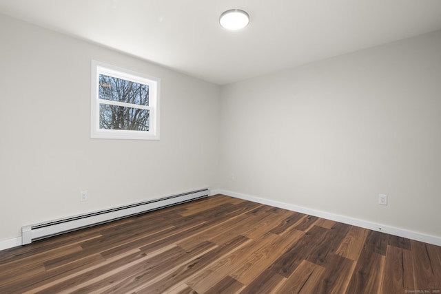 empty room with baseboard heating and dark hardwood / wood-style flooring