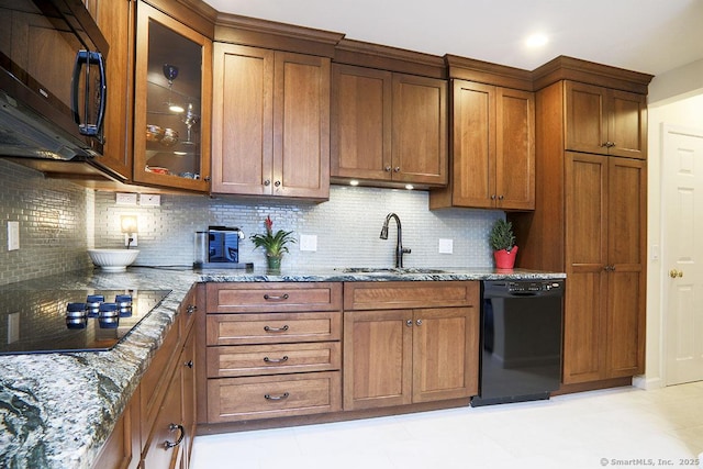 kitchen with light stone countertops, sink, decorative backsplash, and black appliances