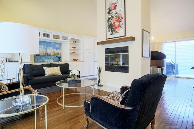 living room with hardwood / wood-style flooring and a towering ceiling