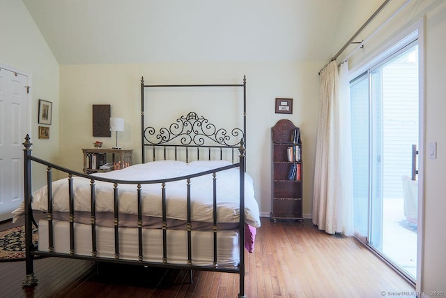 bedroom with wood-type flooring and vaulted ceiling